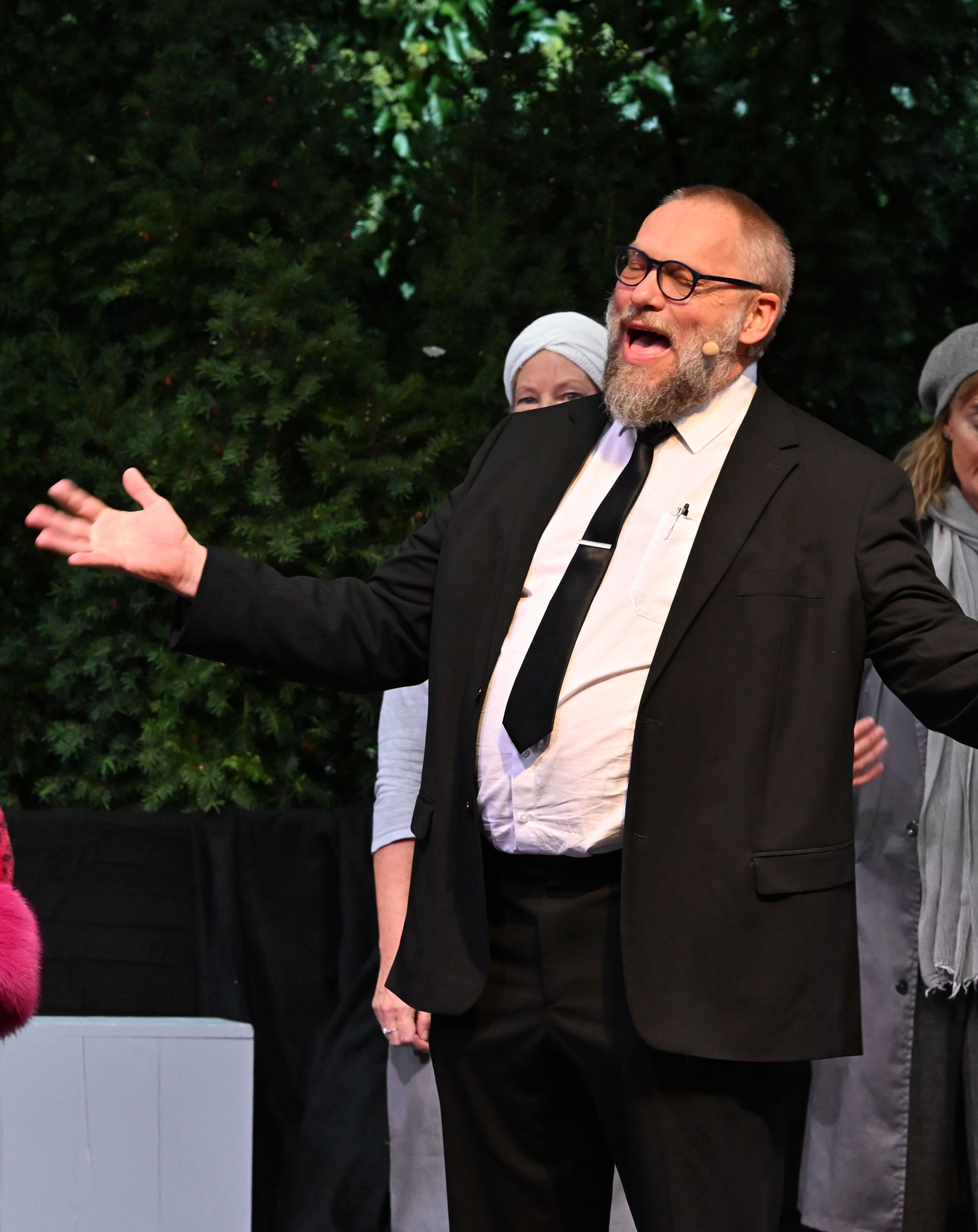 Ein Mann im schwarzen Anzug auf einer Bühne